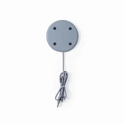 A grey circular magnetic base with four holes and a connected cable. It has a simple, minimalist design.