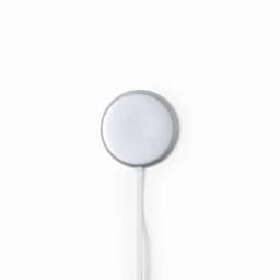 A sleek silver magnetic charging pad with a white cable attached. Features a simple design with no visible branding.