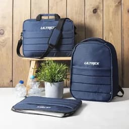 A collection of navy blue bags, including a backpack, a laptop case, and a shoulder bag, arranged on a wooden surface.