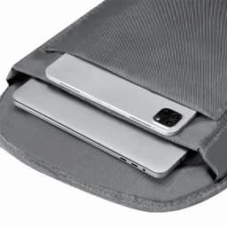 A grey backpack featuring a padded compartment with a smartphone and a laptop inside.