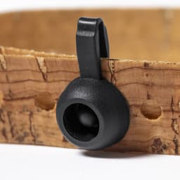 A cork strap with a black fastening clip, featuring a circular opening and textured surface.