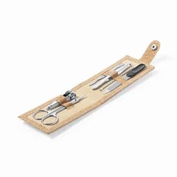 A grooming kit with silver metal tools including scissors, clippers, and nail files, housed in a natural fibre case.