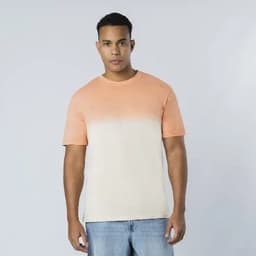 A T-shirt in a gradient of orange and cream tones, featuring short sleeves and a relaxed fit. It has a visible logo.
