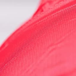 A close-up of a vibrant pink fabric with a textured surface, showcasing its intricate details.