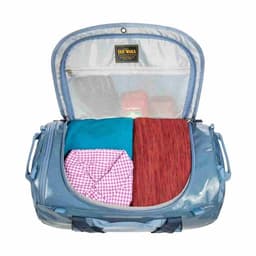 A blue duffel bag opened to reveal neatly folded clothing inside. The bag features a mesh pocket and a logo.