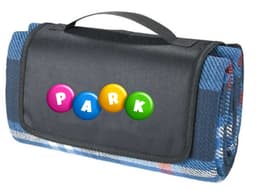 A blue picnic rug with a patterned underside, featuring a black carrying handle and a logo on the front.