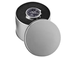 A round silver watch case containing a dark watch, set against a textured black background.