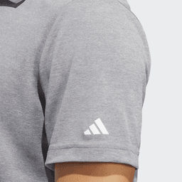 A grey polo shirt with a short sleeve featuring a logo on the arm.