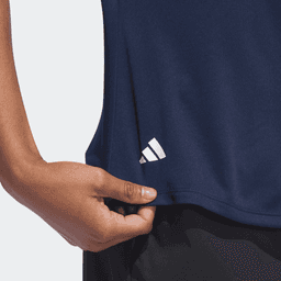 A navy polo shirt featuring a logo, showcasing a close-up of the hem and hand holding the fabric.