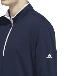 A navy blue quarter zip pullover with a white zip and an athletic logo on the sleeve.