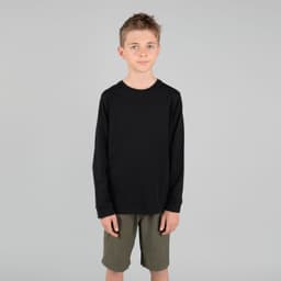 A youth long sleeve tee in black, featuring a simple design and worn by a child, paired with khaki shorts.