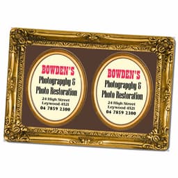 A decorative gold magnetic photo frame featuring two oval spaces for photos or information, set against a brown background.