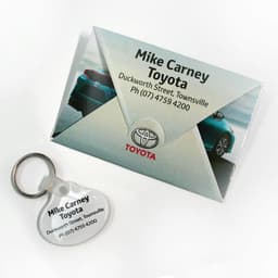 A key tag and a grey presentation folder featuring a logo and an image of a car.