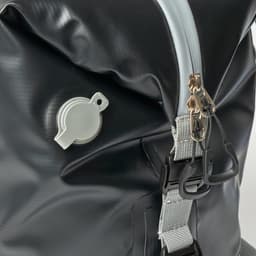 A foldable cooler in black with a grey zip and a drainage valve, featuring clips and a textured surface.