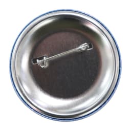 A round 90mm button badge featuring a silver backing with a safety pin attachment. The outer rim is blue.