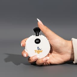 A white, circular spinner with a black lever, held in a hand, featuring a logo on the front.