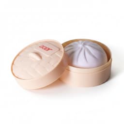 A squishy bun in a round, light peach container with a lid, featuring a soft purple bun inside.