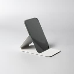 A compact, sleek pocket mirror in grey, with a sturdy white stand for easy positioning. It features a logo.
