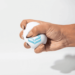 A white squeeze ball is being held, featuring a blue logo. The ball is shown being squeezed by a hand.