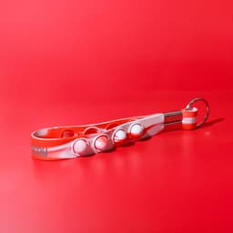 A red and white Popper Stress Reliever Key Chain with multiple popping buttons and a key ring attachment.