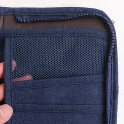 A navy blue passport holder featuring mesh pockets and card slots, with a zip closure.