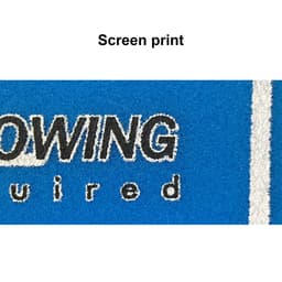 A close-up of a blue fabric showcasing screen print detailing, including black and white text elements.