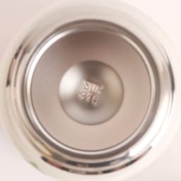A stainless steel insulated food jar with a smooth metallic interior and a silver finish, featuring a circular base.
