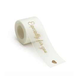 A roll of ivory organza ribbon with gold text and a small heart design. The product has a logo on the packaging.