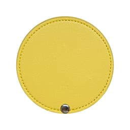 A round makeup mirror in bright yellow with a textured finish and a silver snap button.