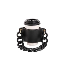 A drink bottle holder in black leather with a chunky acrylic strap, featuring a circular cutout for the bottle.