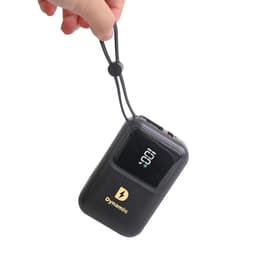 A hand holds a black portable power bank with a digital display and a logo, featuring a convenient strap.