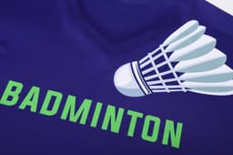 A purple long-sleeve V-neck shirt featuring a badminton shuttlecock design and the word "BADMINTON" in green.
