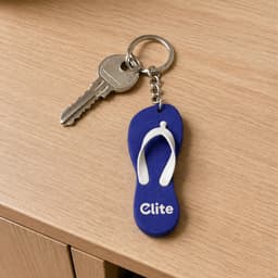 A blue and white thongs-shaped EVA keychain with a metal key attached, featuring a logo.
