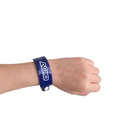 A blue disposable reflective PVC wristband is worn on a wrist. The wristband features a logo.