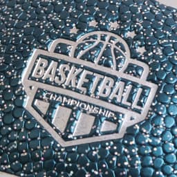 A textured mini basketball in teal with metallic accents and an embossed logo.
