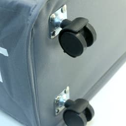 A grey laundry basket with wheels and metal fittings positioned on a flat surface.