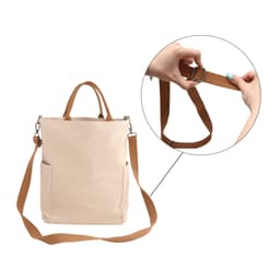 A beige vintage-style canvas bag with a brown adjustable strap and side pockets, featuring a hand adjusting the strap.