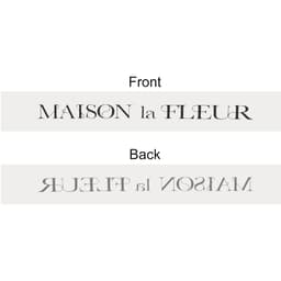 A grey soft ribbon featuring a logo on both sides, with elegant lettering in contrasting colours.