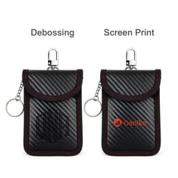 A black carbon fibre Faraday key pouch with red stitching, featuring a clasp and a keyring. It has a logo displayed.