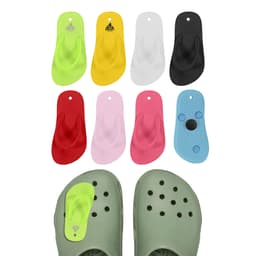 Colourful thong-shaped clog shoe charms in lime green, yellow, red, pink, white, black, and blue, arranged with a pair of green clogs.