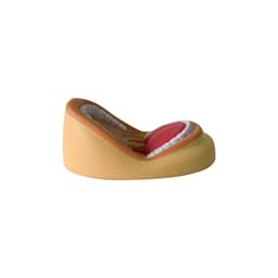 A mouth-shaped stress reliever in brown and pink, featuring white teeth and a red tongue. It has a logo on the side.