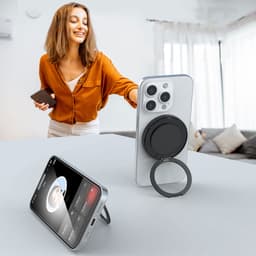 A black Magnetic Wireless Charge Stand is displayed next to a smartphone, with a woman reaching for her phone in a bright room.