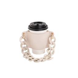 A drink bottle holder in beige leather with an acrylic strap, featuring gold-tone hardware and a cup included.