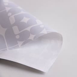 Wrapping paper featuring a white design with grey geometric patterns. The paper has a smooth, glossy finish.