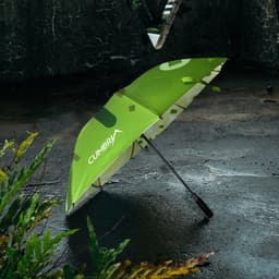 A bright green golf umbrella with a patterned design, featuring a logo on the canopy, set against a textured background.