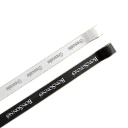 A length of ribbon in white and black, each with a gold edge and featuring a logo.