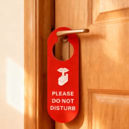 A red PVC door hanger with a circular cutout, displaying a design and a logo.