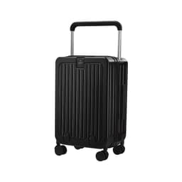 A hardside suitcase in black, featuring a vertical ribbed design, retractable handle, and wheels for mobility.