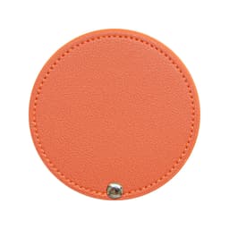 A round makeup mirror with an orange textured surface and a silver snap closure. It features a simple, sleek design.