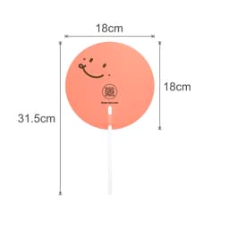 A custom-shaped transparent PVC hand fan in peach with a smiling face design and a white handle. Dimensions are 18cm by 31.5cm.